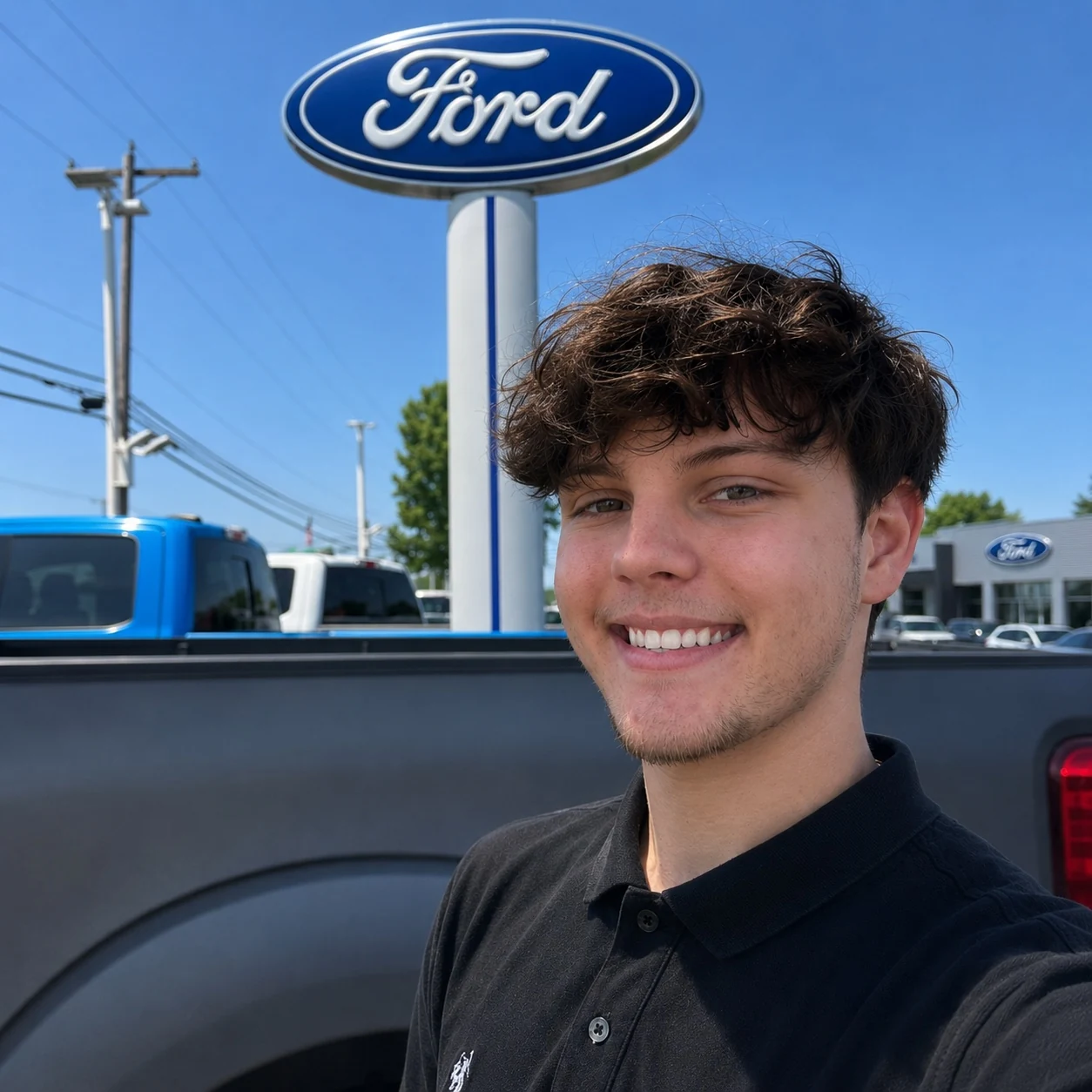 DJ Walton smiling at Freehold Ford with a Ford dealership sign behind him